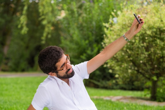 공원에서 selfie를 복용하는 젊은 hipster 남자