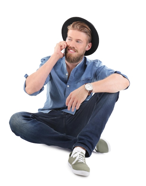 Young hipster man talking on phone against white background