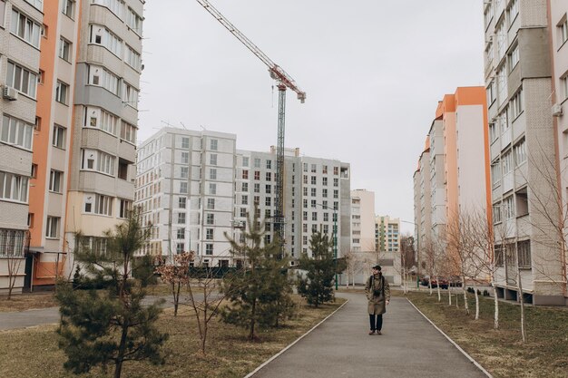 Foto il giovane uomo hipster cammina per strada tra le nuove case