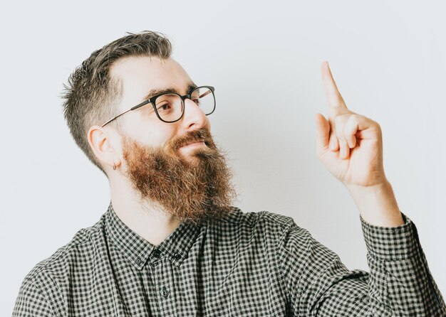 Photo young hipster man with beard and glasses having an idea with a white background. hipster man expression, happy smiling to camera. removable background, commercial ad concept.