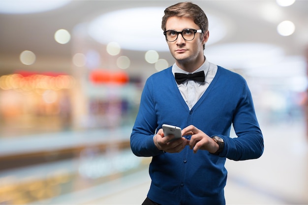 Young hipster man with bow tie and smartphone