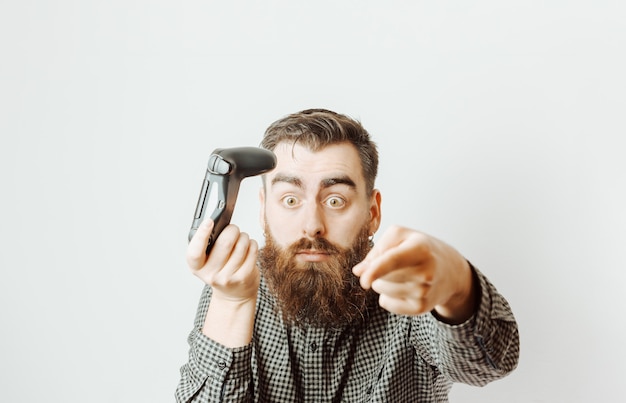 A young hipster man with a white background holding a console pad while surprised signaling something out