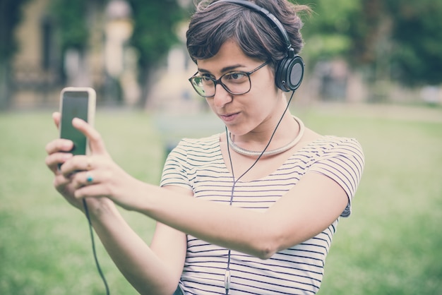 young hipster woman listening to music selfie