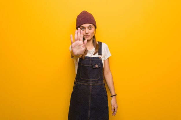 Young hipster woman putting hand in front