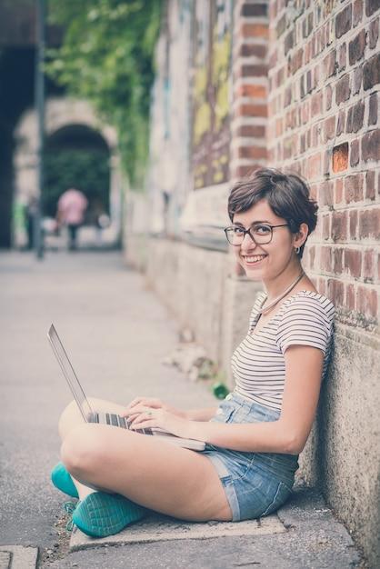 ノートを使用している若いヒップスターの女性