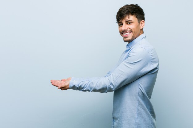 Young hispanic business man holding a copy space on a palm.