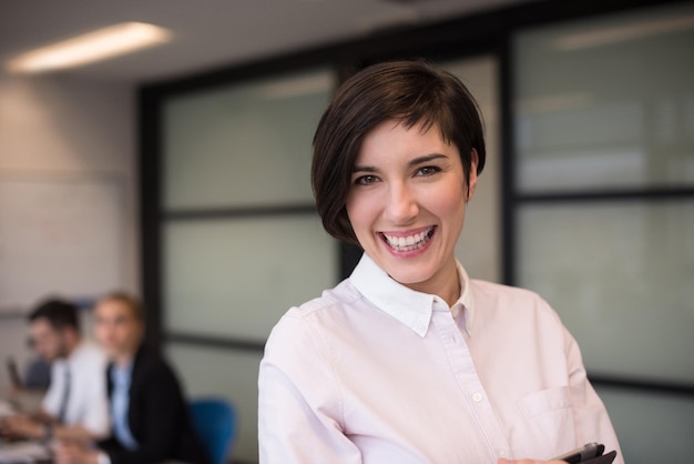 young hispanic businesswoman portrait with  tablet computer at modern startup business office interior, people group on team meeting blured in background