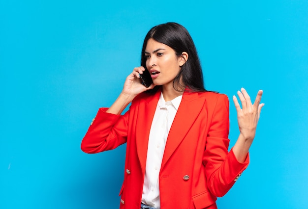 Young hispanic businesswoman using her telephone