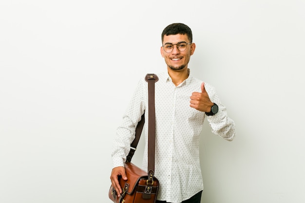 Young hispanic casual business man smiling and raising thumb up