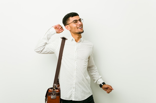 Young hispanic casual business man stretching arms, relaxed position.