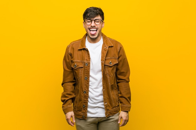 Young hispanic casual man funny and friendly sticking out tongue.