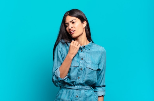 Young hispanic casual woman feeling stressed, anxious, tired and frustrated, pulling shirt neck, looking frustrated with problem