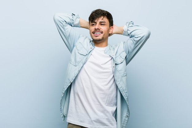 Young hispanic cool man stretching arms, relaxed position.