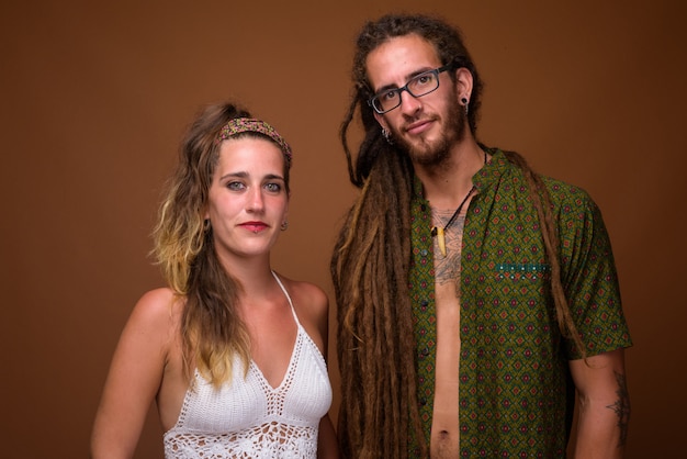 Photo young hispanic couple together against brown background