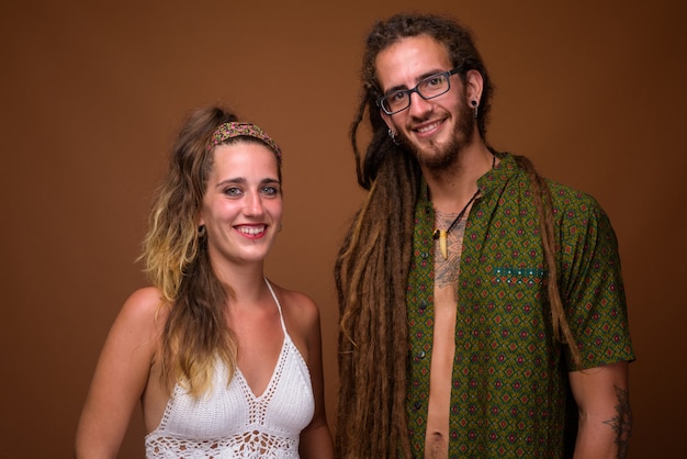 Young Hispanic couple together against brown background