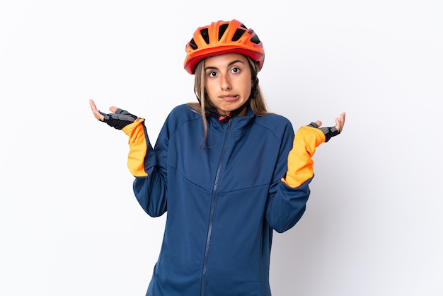 Young hispanic cyclist woman isolated having doubts while raising hands