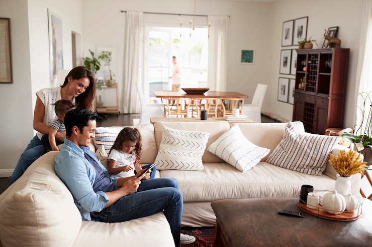 Photo young hispanic family sitting on sofa reading a book together in their living room