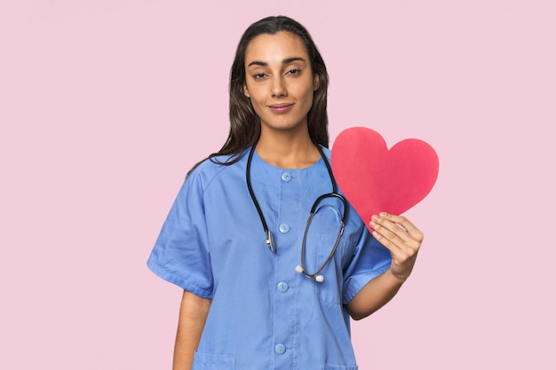 Young Hispanic female nurse holding a heart symbol happiness