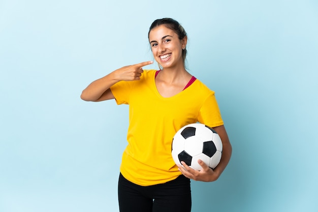 Young hispanic football player woman over isolated on blue background giving a thumbs up gesture