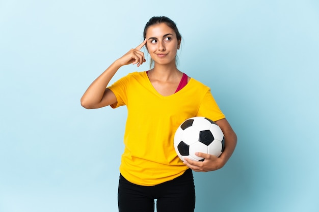 Young hispanic football player woman over isolated on blue background having doubts and thinking