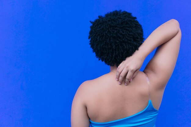 Young hispanic girl in a blue blouse looking backwards