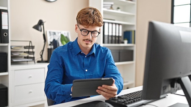 Young hispanic man business worker using touchpad at the office