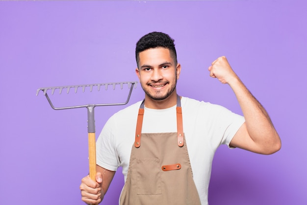 Young hispanic man celebrating successful a victory. farmer or gardener concept