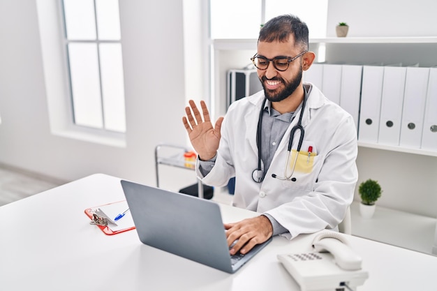 Young hispanic man doctor having video call at clinic