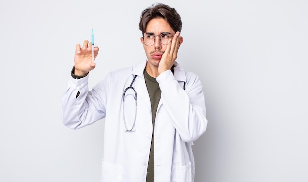 Young hispanic man feeling bored, frustrated and sleepy after a tiresome. doctor syringe concept