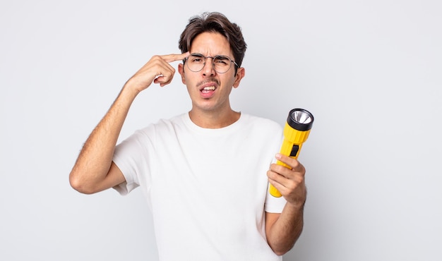 Young hispanic man feeling confused and puzzled, showing you are insane. lantern concept