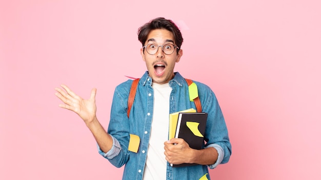 Young hispanic man feeling happy and astonished at something unbelievable. student concept