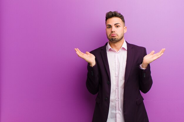 Young hispanic man feeling puzzled and confused, doubting, weighting or choosing different options with funny expression