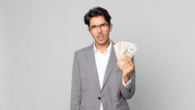 Young hispanic man feeling puzzled and confused