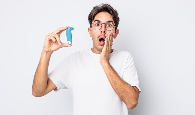 Young hispanic man feeling shocked and scared. asthma concept