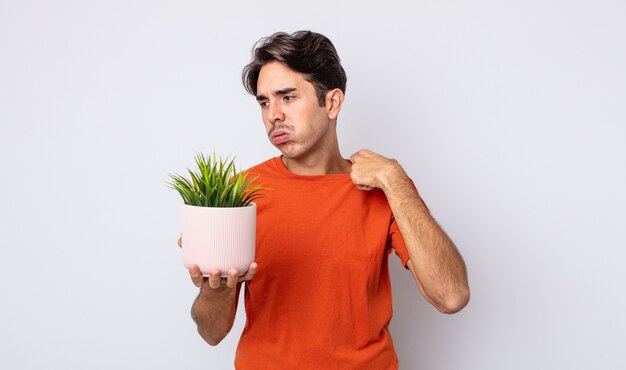 ストレス、不安、倦怠感、欲求不満を感じている若いヒスパニック系男性。観賞植物のコンセプト
