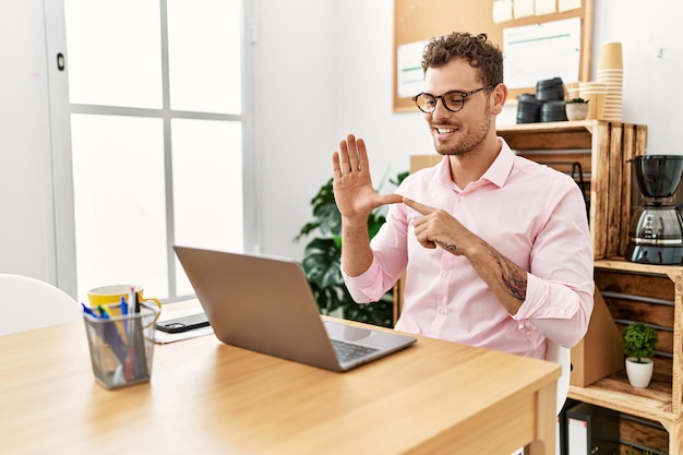 Young hispanic man having video call communicating with deaf sign language at office