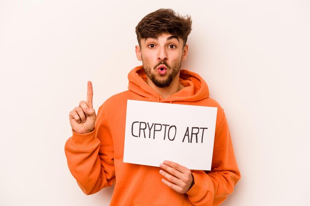 Young hispanic man holding a crypto art placard isolated on white background having some great idea concept of creativity