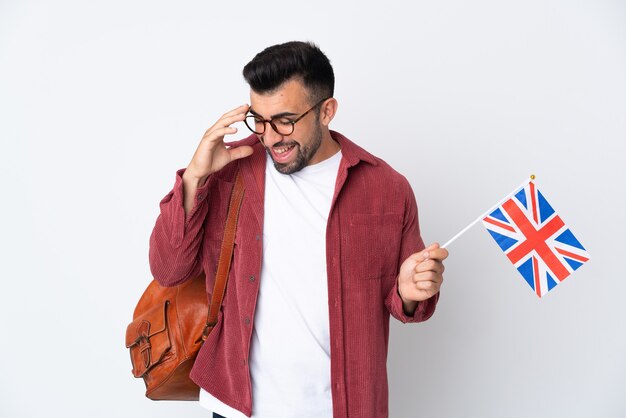 Young hispanic man holding an United Kingdom flag laughing