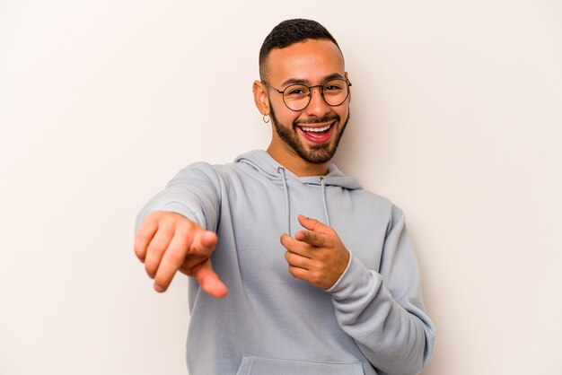 Young hispanic man isolated on white background cheerful smiles pointing to front