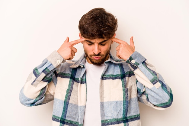 Young hispanic man isolated on white background focused on a task keeping forefingers pointing head