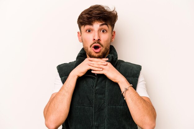 Young hispanic man isolated on white background praying for luck amazed and opening mouth looking to front