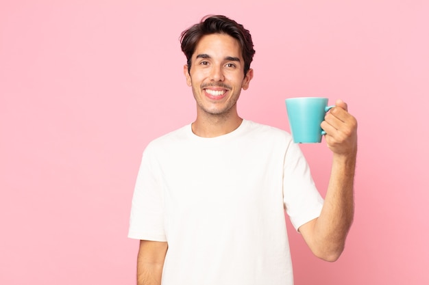 Young hispanic man looking happy and pleasantly surprised and holding a coffee mug