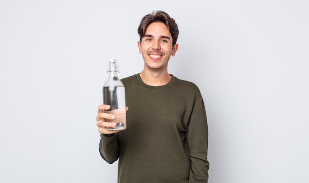 Young hispanic man looking happy and pleasantly surprised. water bottle concept