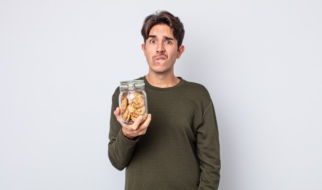 Young hispanic man looking puzzled and confused. cookies concept