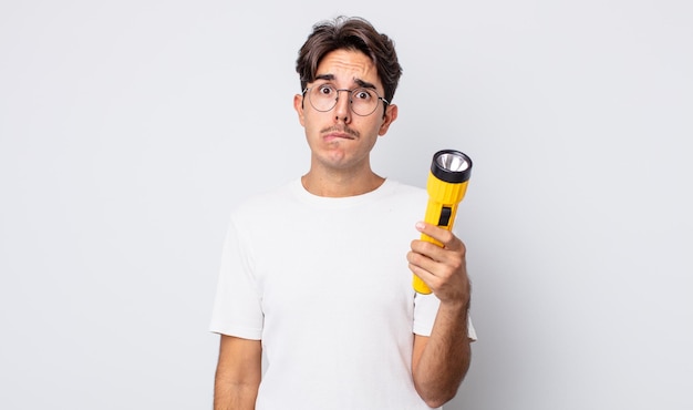 Young hispanic man looking puzzled and confused. lantern concept