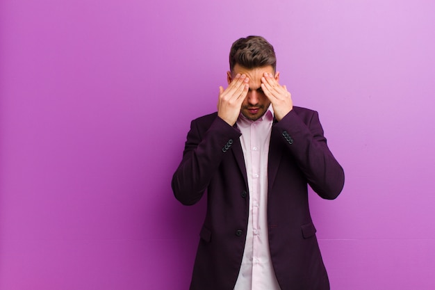 Young hispanic man looking stressed and frustrated, working under pressure with a headache and troubled with problems