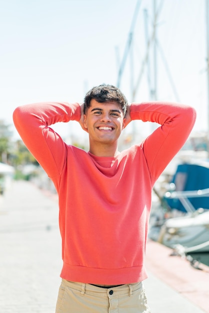 Young hispanic man at outdoors with surprised expression