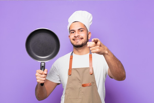 Young hispanic man pointing or showing chef concept