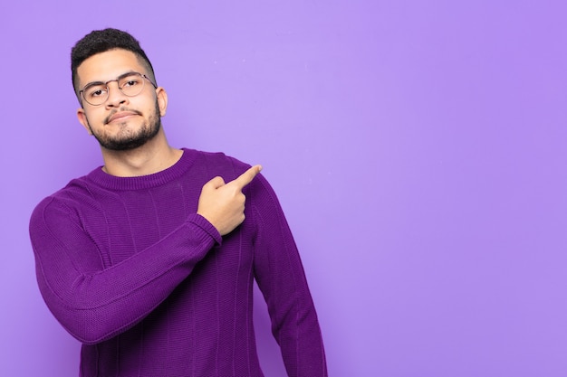 Young hispanic man pointing or showing