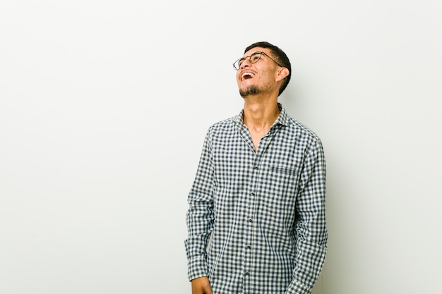 Young hispanic man relaxed and happy laughing, neck stretched showing teeth.